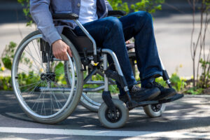 Person using a wheelchair in a park, secured with disability insurance from Le’Risque Africa